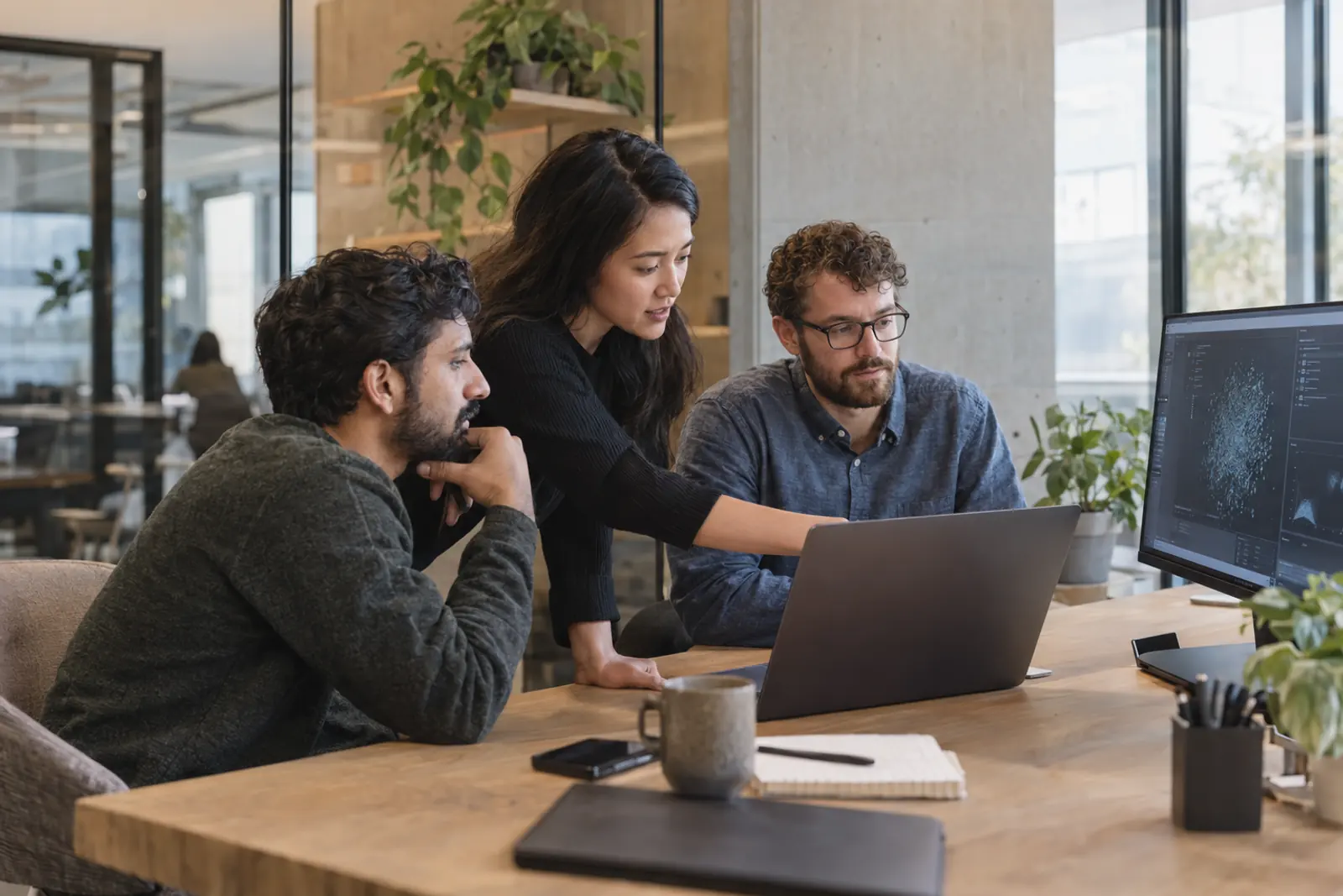 Illustrative software engineers collaborating around a laptop and data visualization